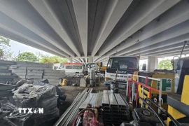 Dưới gầm cầu Lò Gốm tập kêt nhiều vật tư xây dựng dễ xảy ra nguy cơ cháy, nổ khi có sự cố. (Ảnh: Linh Sơn/ TTXVN)