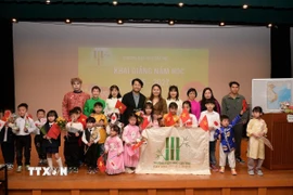 Học sinh, giáo viên và phụ huynh Trường Việt ngữ Cộng đồng Cây Tre chụp hình lưu niệm khóa mới. (Ảnh: Nguyễn Tuyến/TTXVN)