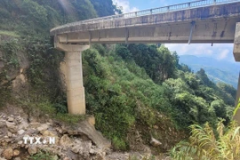 Chân cầu đã bị xói mòn, trơ móng. (Ảnh: Nguyễn Oanh/TTXVN)