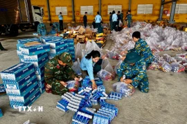 Hàng hóa, lương thực, nhu yếu phẩm được vận chuyển, sắp xếp lên máy bay để hỗ trợ người dân khu vực ngập lụt. (Ảnh: Trần Lê Lâm/TTXVN)