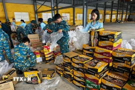 Hàng hóa, lương thực, thực phẩm, nhu yếu phẩm được vận chuyển, sắp xếp lên máy bay chuẩn bị hỗ trợ nhân dân vùng lũ. (Ảnh: Trần Lê Lâm/TTXVN)