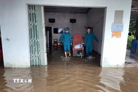 Lực lượng dân quân hỗ trợ người dân di chuyển đồ đạc khỏi vùng ngập lụt ven sông Krông Nô, tỉnh Lâm Đồng. (Ảnh: TTXVN phát)