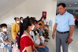 Phó Chủ tịch Ủy ban Nhân dân tỉnh Long An Phạm Tấn Hoà thăm hỏi các gia đình đưa trẻ em đến khám sàng lọc bệnh tim bẩm sinh. (Ảnh: Đức Hạnh/TTXVN)