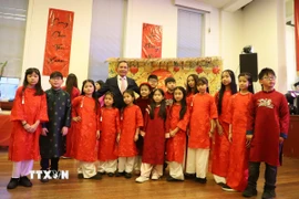 Đại sứ Đỗ Minh Hùng chụp ảnh lưu niệm với các cháu thiếu nhi của Cộng đồng người Việt Nam tại Anh. (Ảnh: Hữu Tiến/TTXVN)