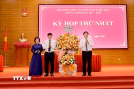 Chủ tịch UBND tỉnh, Phó Bí thư Tỉnh ủy Phú Thọ Trần Duy Đông (phải) tặng hoa chúc mừng lãnh đạo phường Vĩnh Phúc tại kỳ họp. (Ảnh: PV/TTXVN)
