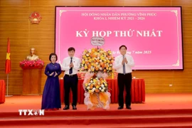 Chủ tịch UBND tỉnh, Phó Bí thư Tỉnh ủy Phú Thọ Trần Duy Đông (phải) tặng hoa chúc mừng lãnh đạo phường Vĩnh Phúc tại kỳ họp. (Ảnh: PV/TTXVN)