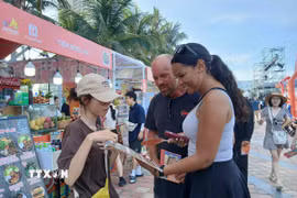 Du khách nước ngoài tìm hiểu các món ăn đặc trưng xứ Quảng tại Lễ hội Food Tour Đà Nẵng 2026. (Ảnh: Mỹ Hà/TTXVN)