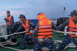 Các chiến sĩ giúp một tàu ngư dân bị nạn. (Ảnh: TTXVN phát)