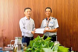 Ông Nguyễn Đức Vũ Trưởng Ban Quản lý đã trao giấy khen và khen thưởng đột xuất cho anh Phan Thanh Trinh (phải). (Ảnh: TTXVN phát).