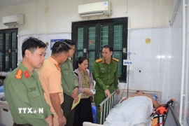 Lãnh đạo Công an tỉnh Hưng Yên thăm hỏi, động viên Đại úy Vũ Trường Giang đang điều trị tại Bệnh viện Việt Đức. (Ảnh: TTXVN phát)