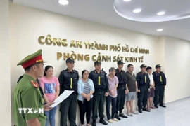 Công an đọc lệnh bắt các đối tượng. (Ảnh TTXVN phát)