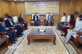 Chủ tịch Hội Nhà báo Việt Nam Lê Quốc Minh đón đoàn đại biểu Hội Nhà báo Lào tới thăm và làm việc. (Ảnh: Nguyễn Trọng Lịch/TTXVN)