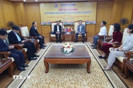 Chủ tịch Hội Nhà báo Việt Nam Lê Quốc Minh đón đoàn đại biểu Hội Nhà báo Lào tới thăm và làm việc. (Ảnh: Nguyễn Trọng Lịch/TTXVN)