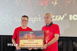 Tổng Biên tập Báo Nhân Dân Lê Quốc Minh trao tặng đến Hội Cựu Chiến binh Thành phố Hồ Chí Minh 1.000 tấm vé “Tổ Quốc Trong Tim: The Concert Film”. (Ảnh: Thu Hương/TTXVN) 