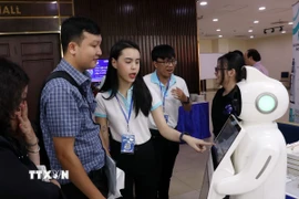 Các đại biểu trải nghiệm công nghệ tại khu trưng bày của Hội thảo. (Ảnh: Tiến Lực/TTXVN)