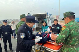 Đồn Biên phòng cửa khẩu Quốc tế Móng Cái (Việt Nam) phối hợp với Trạm kiểm tra Biên phòng xuất nhập cảnh Đông Hưng (Trung Quốc) mở "luồng xanh" cho xe cứu thương cấp cứu bệnh nhân. (Ảnh: TTXVN phát)