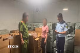 Lực lượng chức năng kiểm tra kho hàng do N.T.T làm chủ. (Ảnh: TTXVN phát)