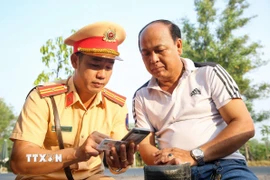 Cán bộ Cảnh sát giao thông Tây Ninh tuyên truyền pháp luật đến các chủ phương tiện. (Ảnh: Giang Phương/TTXVN)
