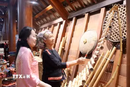 Hướng dẫn du khách trải nghiệm nhạc cụ dân gian của dân tộc Êđê tại bảo tàng Đắk Lắk trong dịp nghỉ lễ 30/4-1/5. (Ảnh: Hoài Thu/TTXVN)