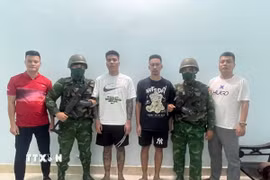 Đối tượng Trần Duyên Thịnh và Nguyễn Tuấn Nam (đứng giữa) cùng trú tại thành phố Hà Nội, bị truy nã về hành vi “Gây rối trật tự công cộng” bị bắt giữ tại Đồn Biên phòng Cửa khẩu quốc tế Mộc Bài. (Ảnh: TTXVN phát)