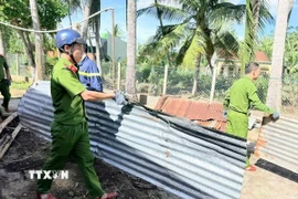 Lực lượng Công an tỉnh Gia Lai giúp người dân lợp lại mái nhà. (Ảnh: Sỹ Thắng/TTXVN)