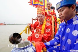 Thực hiện nghi lễ lấy nước. (Ảnh: Khánh Hoà/TTXVN)