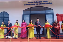 Đại biểu thực hiện nghi thức cắt băng khánh thành thư viện số. (Ảnh: Trần Tĩnh/TTXVN)