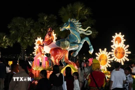 Du khách tham quan linh vật ngựa ở bờ Nam sông Hương, thành phố Huế dịp Tết Bính Ngọ 2026. (Ảnh: Nguyên Lý/TTXVN)