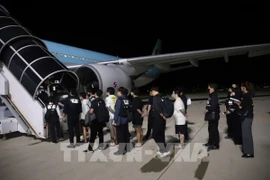 Các công dân Hàn Quốc liên quan hoạt động lừa đảo sử dụng công nghệ được bàn giao tại sân bay quốc tế ở thủ đô Phnom Penh, Vương quốc Campuchia, tối 17/10/2025. (Ảnh: AKP/TTXVN phát)