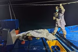 Một nạn nhân được cứu sống (trái) sau vụ chìm thuyền chở người di cư ở khu vực gần biên giới trên biển giữa Malaysia-Thái Lan ngày 9/11/2025. (Ảnh: THX/TTXVN)
