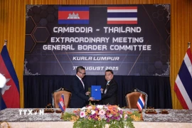 Phó Thủ tướng, Bộ trưởng Quốc phòng Campuchia Tea Seiha (trái) và Thứ trưởng Quốc phòng Thái Lan Nattaphon Narkphanit trao đổi thỏa thuận ngừng bắn tại phiên họp bất thường của Ủy ban biên giới chung hai nước tại Kuala Lumpur, Malaysia, ngày 7/8/2025. (Ảnh: THX/TTXVN)