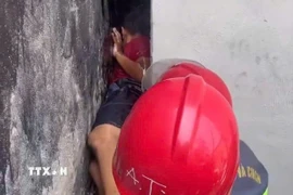 Cảnh sát Phòng cháy, chữa cháy và Cứu nạn, cứu hộ Công an Thành phố Hồ Chí Minh giải cứu kịp thời bé trai mắc kẹt giữa hai bức tường ở phường Bình Cơ. (Ảnh: TTXVN phát)