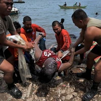 Lực lượng bảo vệ bờ biển Philippines chuyển thi thể một ngư dân vừa tìm thấy. (Ảnh: AFP/TTXVN)