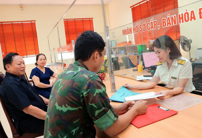 Công chức Chi cục Thuế thành phố Yên Bái hướng dẫn người dân làm thủ tục nộp thuế. (Ảnh: Phạm Hậu/TTXVN)