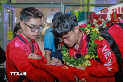 Cầu thủ đội tuyển bóng đá Việt Nam ký tặng người hâm mộ. (Ảnh: Phan Phương/TTXVN)