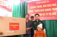 Thiếu tướng Nguyễn Trần Long, Ủy viên Ban Thường vụ Đảng uỷ, Phó Chính ủy Quân đoàn 34, trao tặng quà cho hộ gia đình bà Tô Thị Sửa. (Ảnh: Quang Thái/TTXVN)