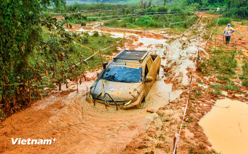 Một chiếc xe tham gia cuộc đua đang "gồng mình" vượt qua những con đường lấp bùn khổng lồ. (Ảnh: PV/Vietnam+)