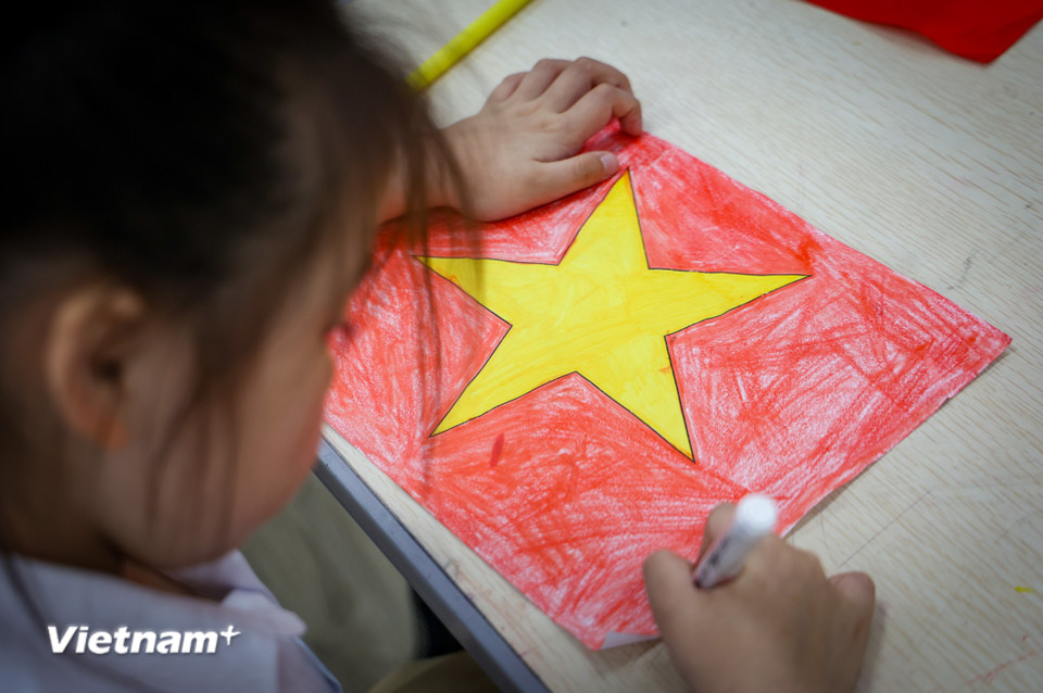 Qua việc vẽ tranh này, em càng hiểu thêm về ý nghĩa của lá cờ và càng thêm tự hào và yêu đất nước mình hơn,” Chi cho hay. (Ảnh: Minh Hiếu/Vietnam+)
