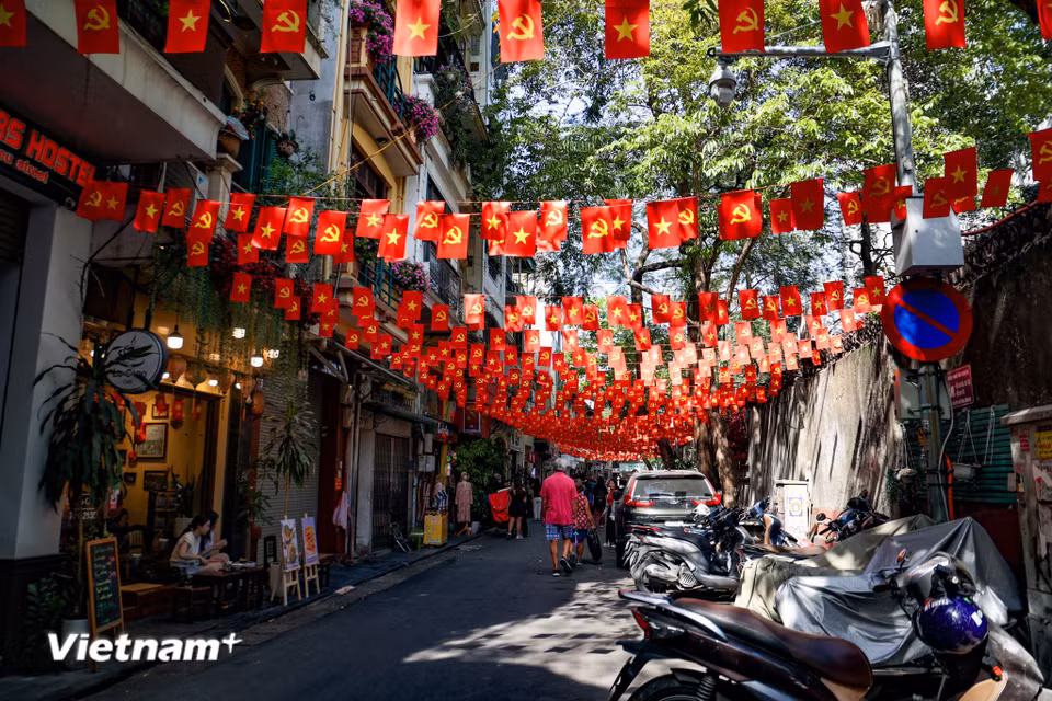 Những ngày cuối tháng Tư, từ những con ngõ nhỏ bình dị đến những tuyến phố trung tâm sầm uất, khắp nơi đều ngập tràn sắc cờ đỏ sao vàng phấp phới trong nắng. (Ảnh: Minh Hiếu/Vietnam+)