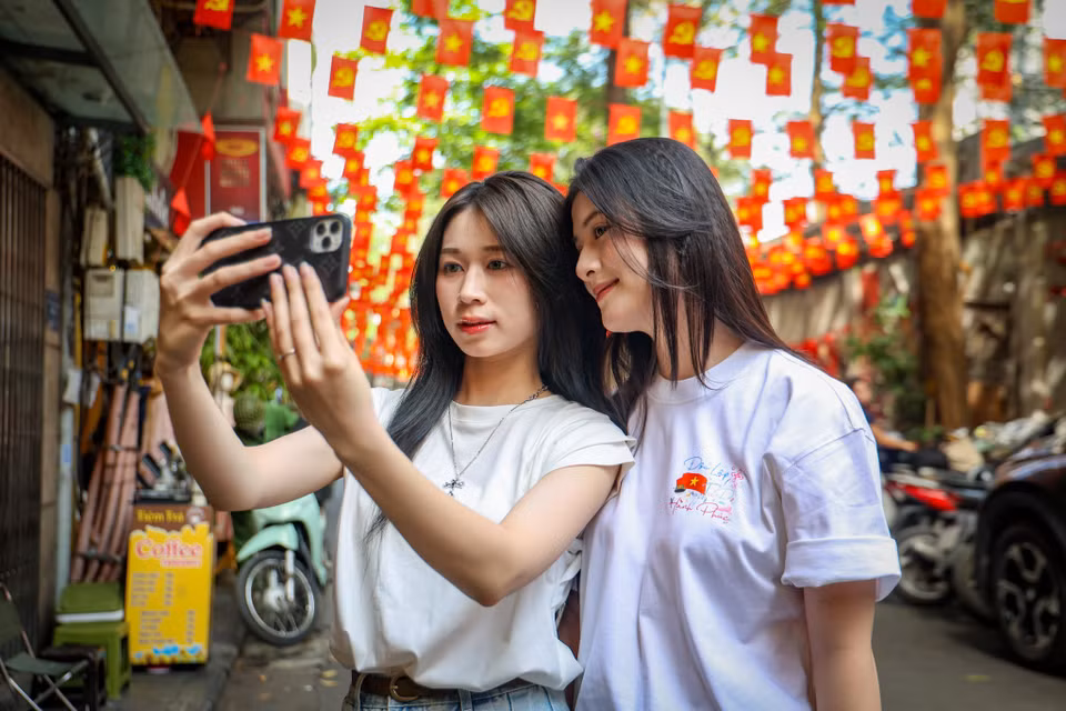 Đông đảo người dân, đặc biệt là các bạn trẻ đổ về con phố Ấu Triệu để chụp ảnh, lưu giữ những khoảnh khắc trang trọng chuẩn bị đón lễ kỷ niệm 50 năm ngày Giải phóng miền Nam, Thống nhất đất nước. (Ảnh: Minh Hiếu/Vietnam+)
