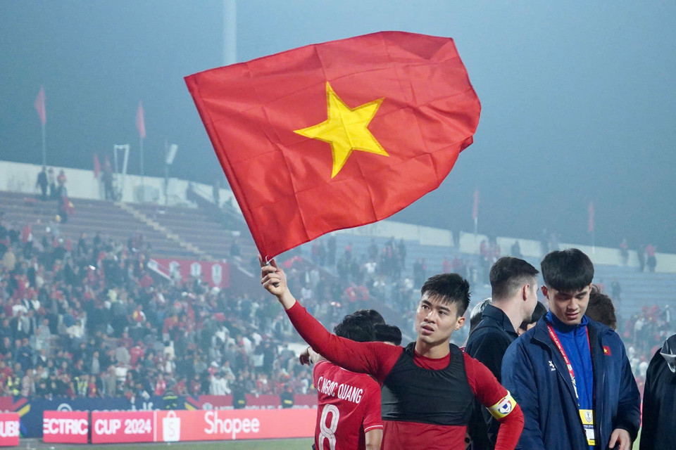 Đội trưởng Duy Mạnh ăn mừng với lá Quốc kỳ sau chiến thắng. (Ảnh: Việt Anh/Vietnam+)