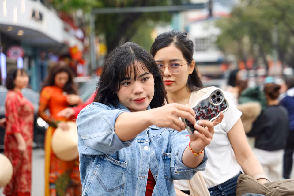 Các bạn trẻ check-in với toà nhà. (Ảnh: Minh Hiếu/Vietnam+)