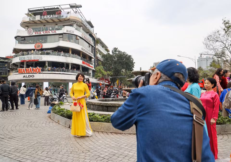Người dân từ trẻ đến già; lớn đến bé... Ai nấy cũng đều nô nức diện quần áo, chụp những bức ảnh kỷ niệm với tòa nhà "Hàm cá mập" - một biểu tượng của khu vực Hồ Hoàn Kiếm sắp bị phá dỡ. (Ảnh: Minh Hiếu/Vietnam+)