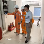 Công nhân (EVNHANOI) hướng dẫn khách hàng sử dụng điện an toàn, tiết kiệm. (Ảnh: Quốc Lũy/ TTXVN)