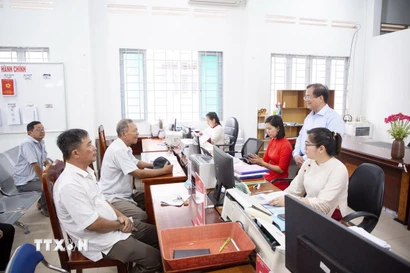 Phó Chủ tịch UBND tỉnh Tây Ninh Nguyễn Hồng Thanh (đứng bên phải) lắng nghe ý kiến của nhân dân đến làm thủ tục hành chính tại Trung tâm phục vụ Hành chính công xã Tân Đông. (Ảnh: Giang Phương/TTXVN)