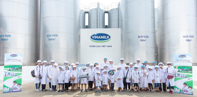 Mọi người chụp ảnh cùng các bồn chứa lạnh khổng lồ, nơi chứa khối lượng lớn sữa tươi nguyên liệu sau khi được vận chuyển từ các trang trại chuẩn GLOBAL G.A.P về nhà máy. (Ảnh: CTV) Vinamilk tổ chức cho các khách hàng nhí tham quan 'Siêu nhà máy' ảnh 3