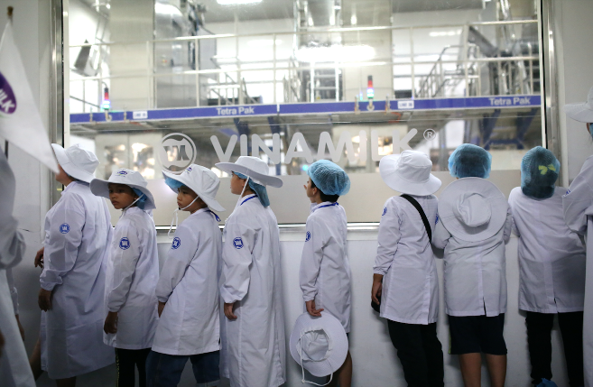 Các vị khách sữa học đường "nhí" chăm chú ngắm nhìn quy mô siêu nhà máy hiện đại. Lần đầu tiên những khách mời được tận mắt thấy công nghệ tiệt trùng UHT và công nghệ chiết rót vô trùng của Vinamilk. (Ảnh: CTV) Vinamilk tổ chức cho các khách hàng nhí tham quan 'Siêu nhà máy' ảnh 4