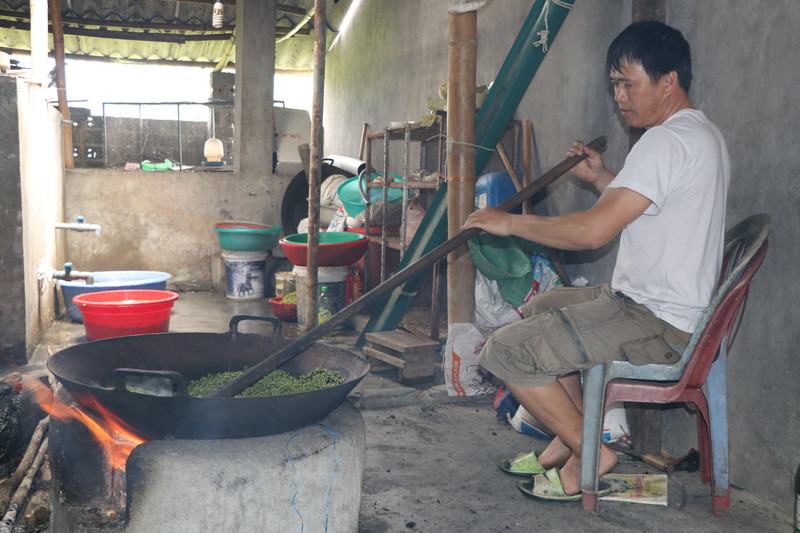 Sau khi được tuốt, loại bỏ hạt lép, lúa được đem rang trong chảo lớn. Lửa phải được duy trì đều trong khoảng 30 phút đến khi nứt hạt và dậy mùi thơm. (Ảnh: Tiến Khánh/TTXVN)