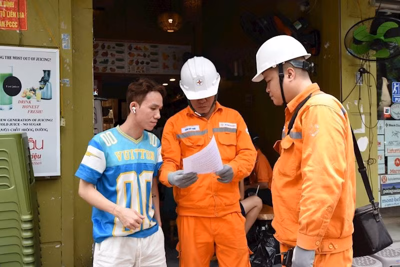 Cán bộ EVNHANOI tuyên truyền tiết kiệm điện đến từng hộ gia đình. (Ảnh: evnhanoi)