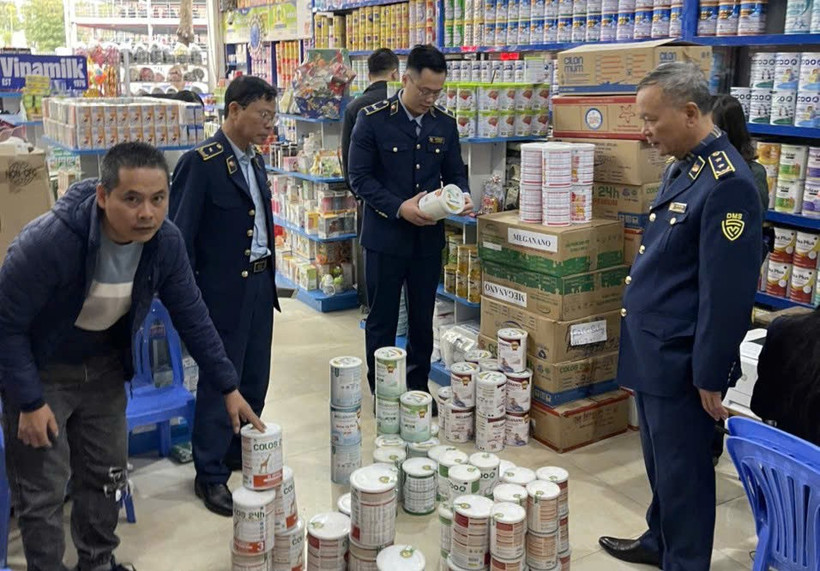 Lực lượng chức năng kiểm tra mặt hàng sữa. (Ảnh: PV/Vietnam+)